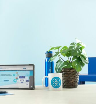 a laptop computer sitting on top of a table next to a potted plant